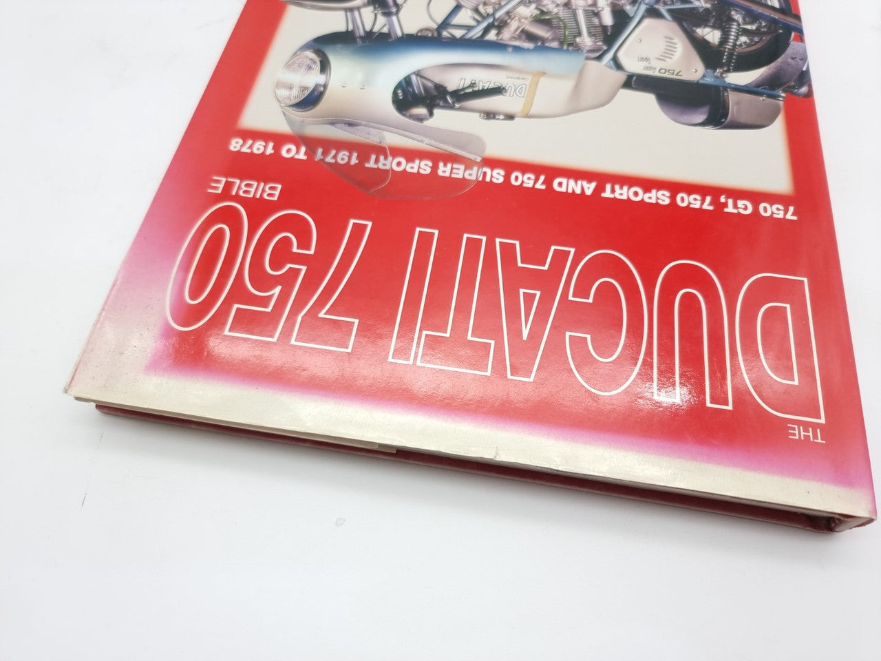 Motorcycle history book cover with reversed red title and Ducati 750 branding
