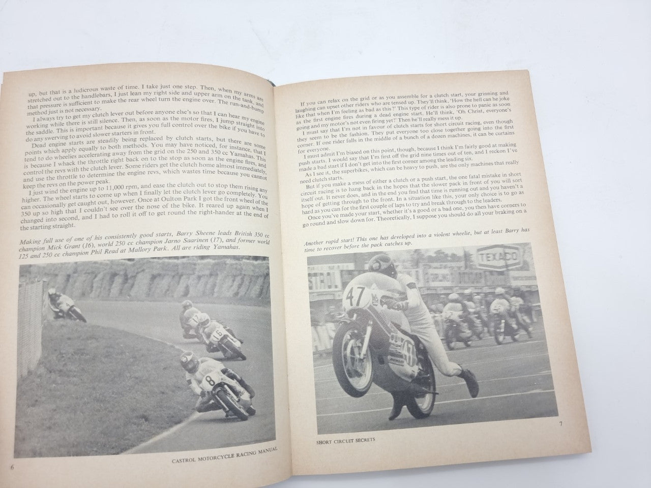 Open motorcycle racing manual with two pages of text and black-and-white race action photos