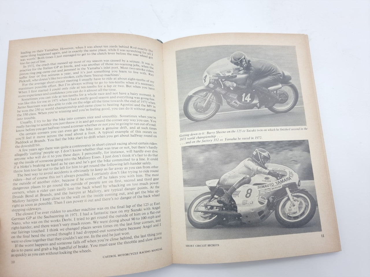 Open motorcycle racing manual spread with racing photos and captions on the right page