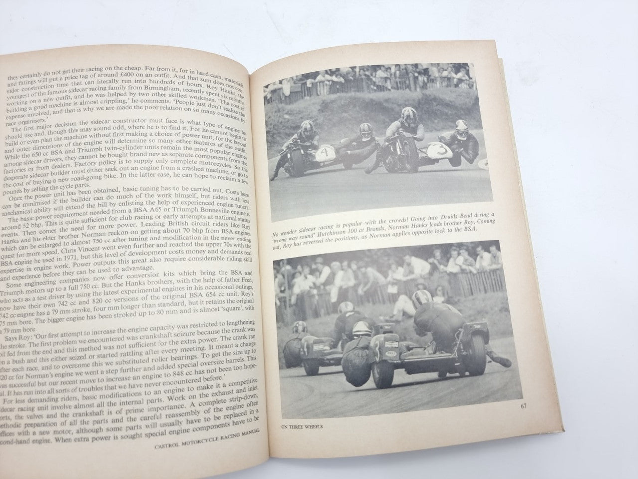 Motorcycle racing manual open to text and vintage photo of three race motorcycles