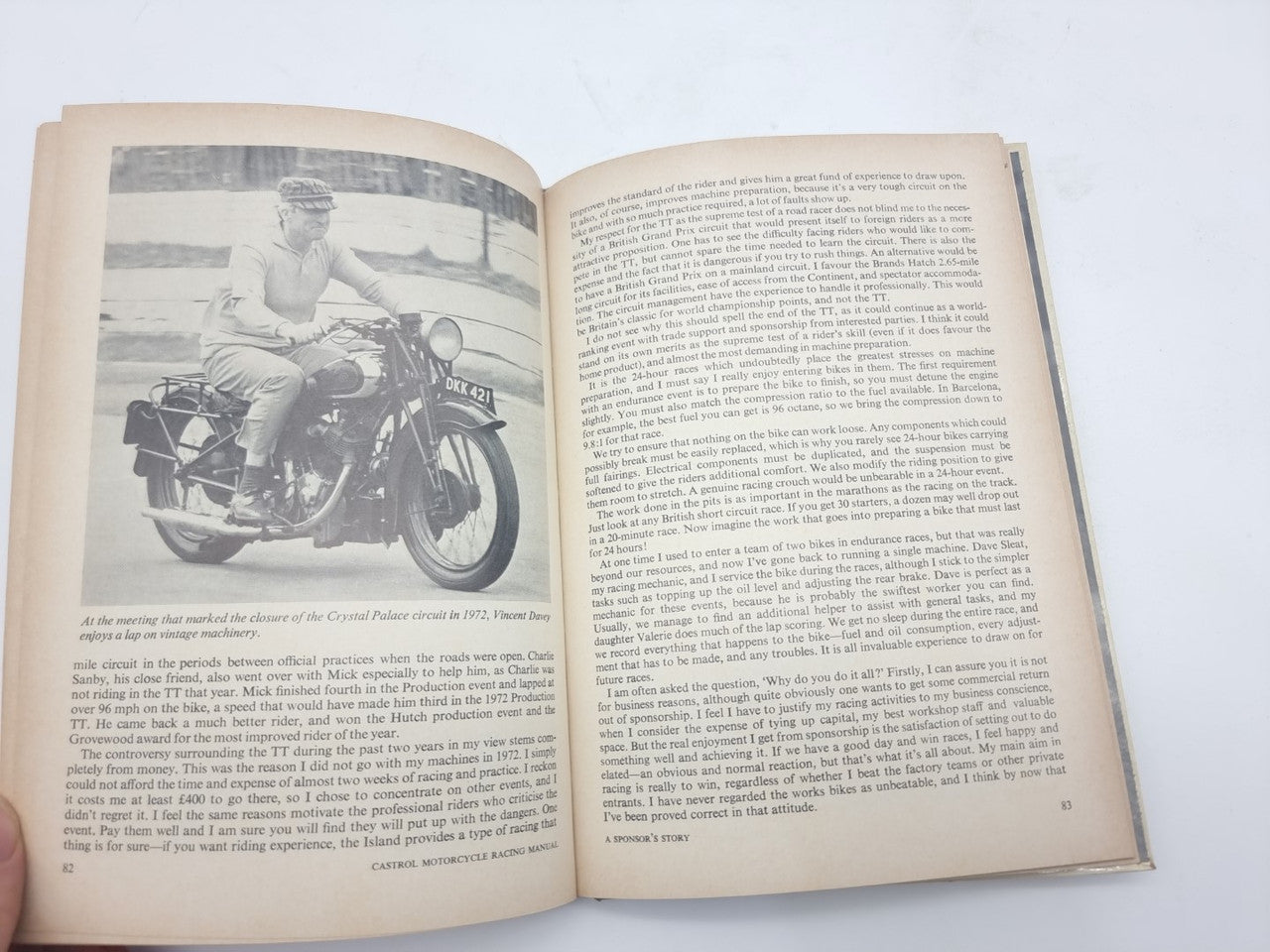 Motorcycle racing manual open page with motorcycle photo and dense paragraphs of text