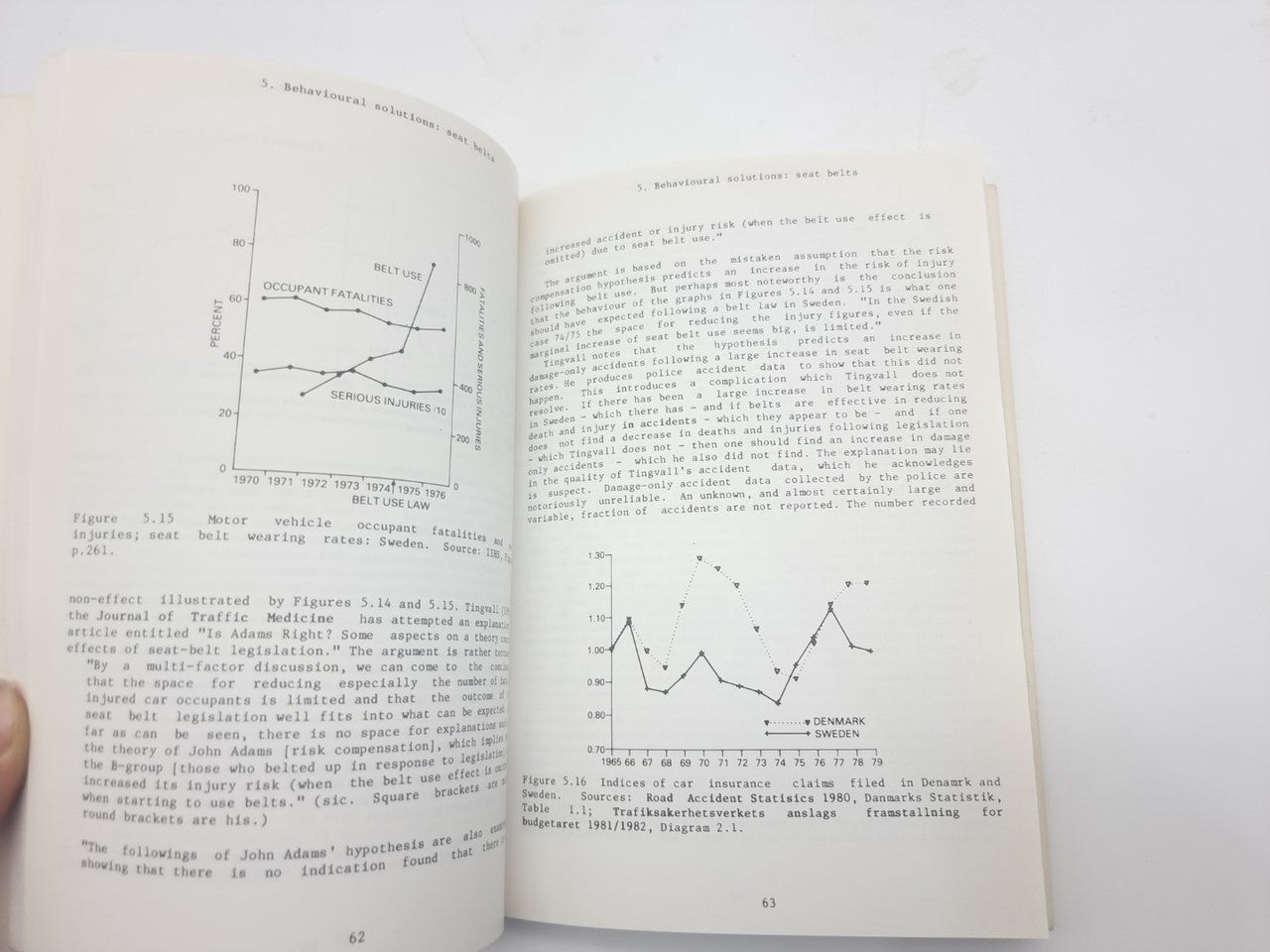 Opened book pages with printed charts, line graphs, and paragraph text