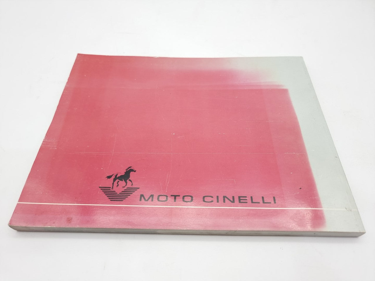 Red book cover with “Moto Cinelli” logo on the bottom side