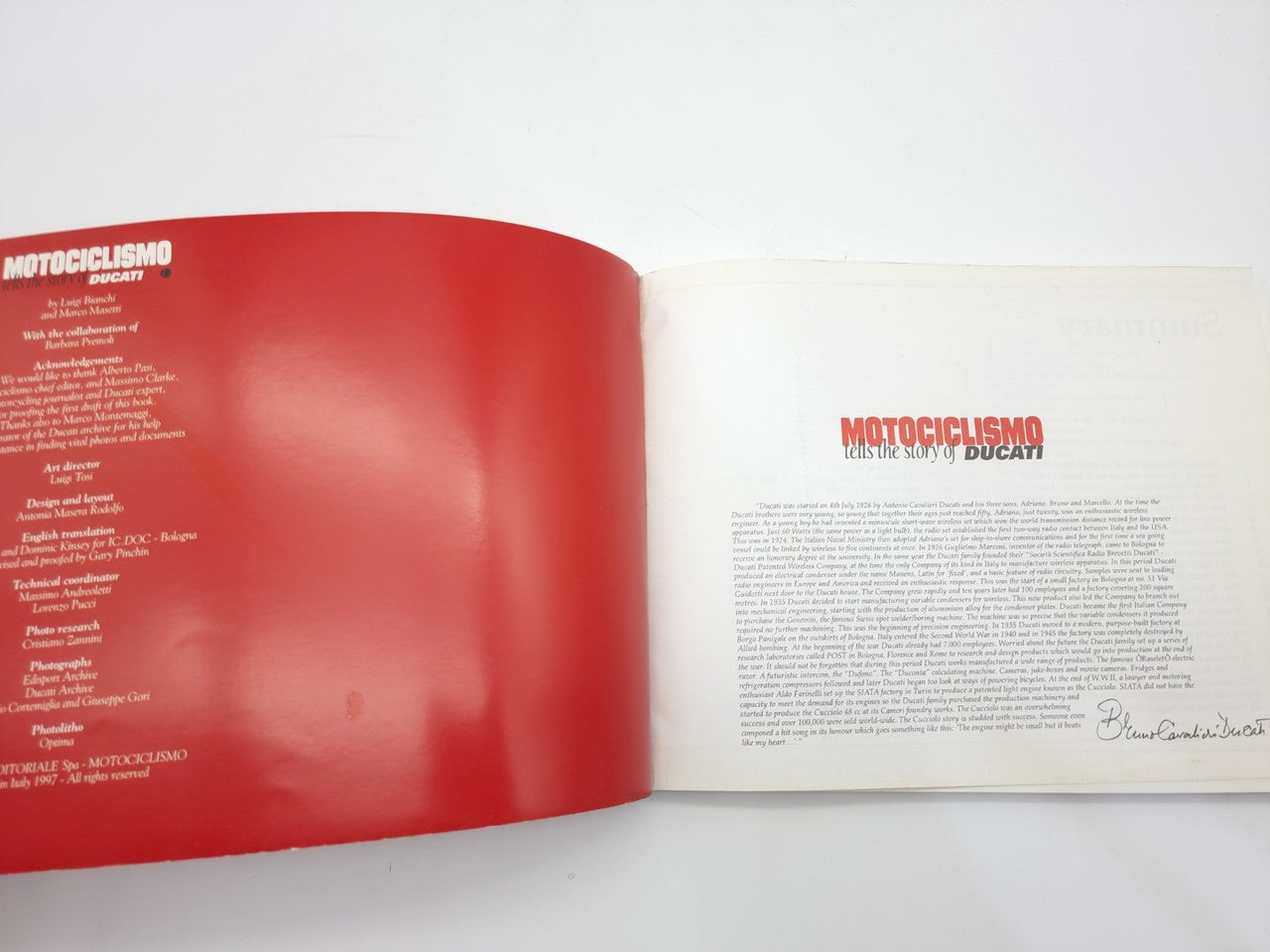 Opened book spread with left red page and right title page for Ducati story