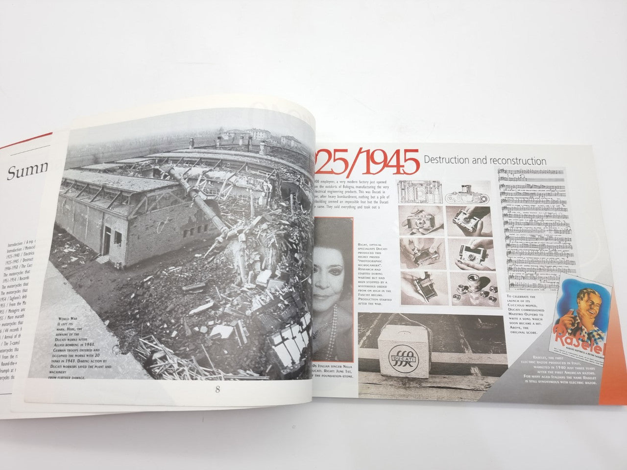 Open motorcycle history book spread with wreck photo and restoration diagrams