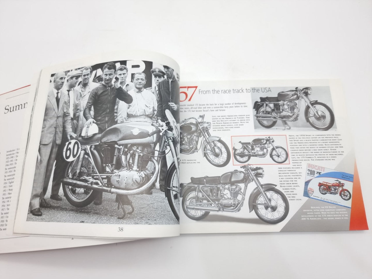 Open motorcycle history book spread with riders, numbered bikes, and side-by-side photos