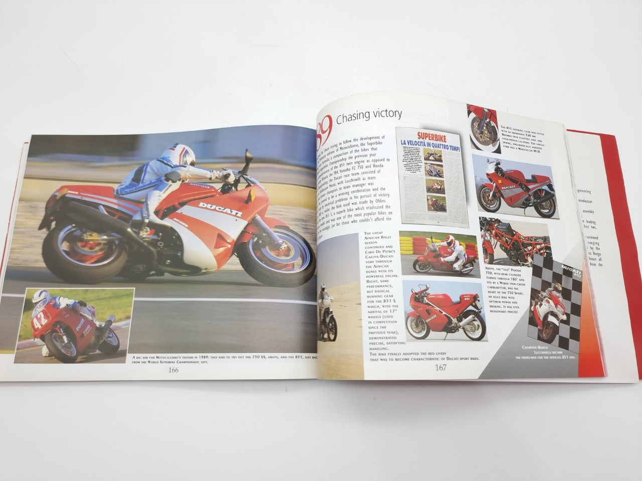 Open motorcycle history book spread with orange-and-white Ducati motorcycle photo