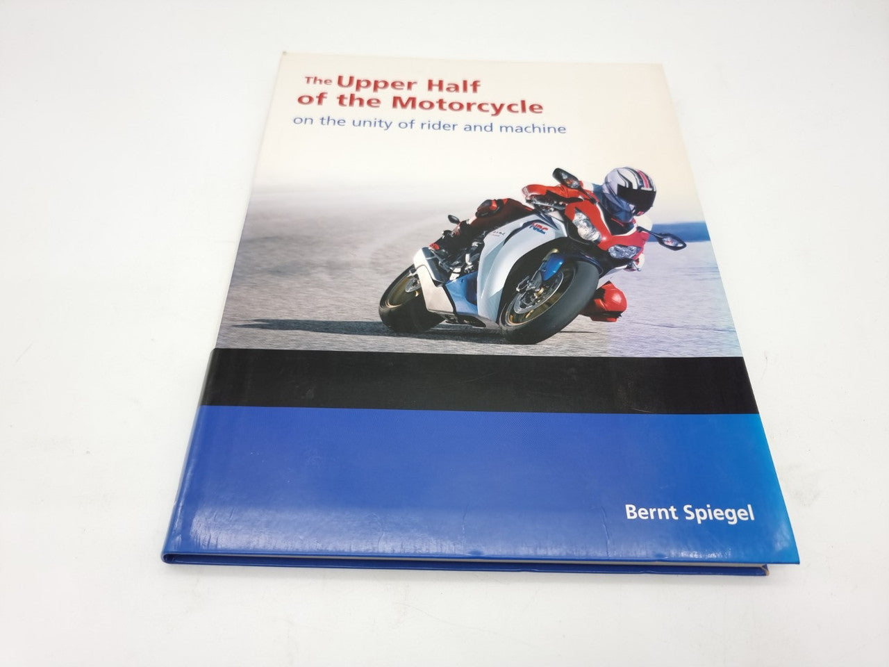 Hardcover book with motorcycle cover art and blue lower band, Bernt Spiegel