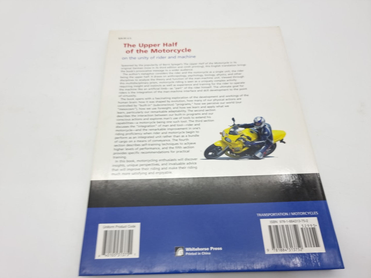 Hardcover book back cover with text, barcodes, and blue bottom strip