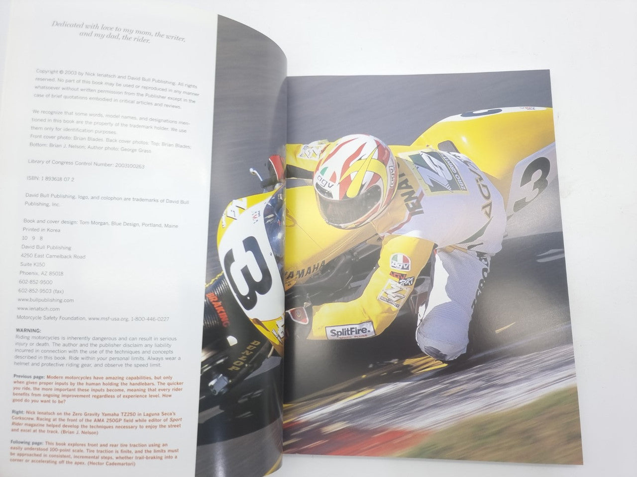 Open book page with a close-up photo of a racing motorcycle rider in yellow gear