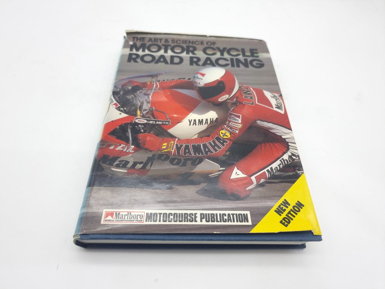 Motorcycle road racing book, red race bike cover with 'New Edition' yellow label