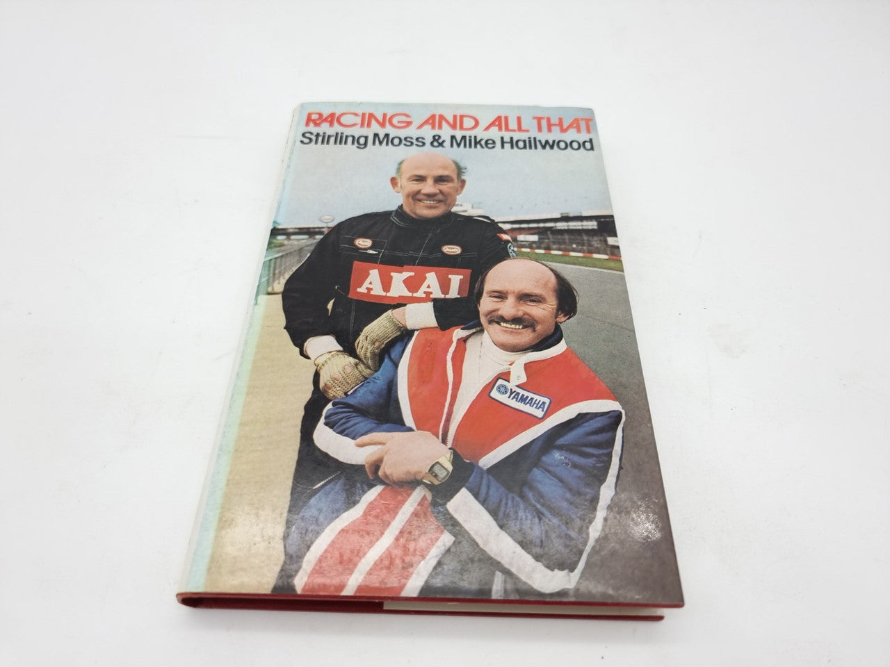 Racing and All That book cover with two drivers and AKAI logo