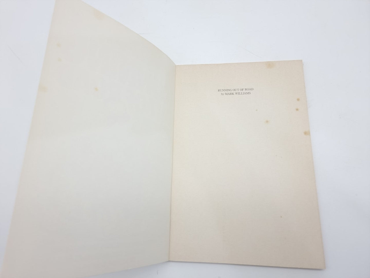 Vintage paperback book, open blank pages with centered title near the top