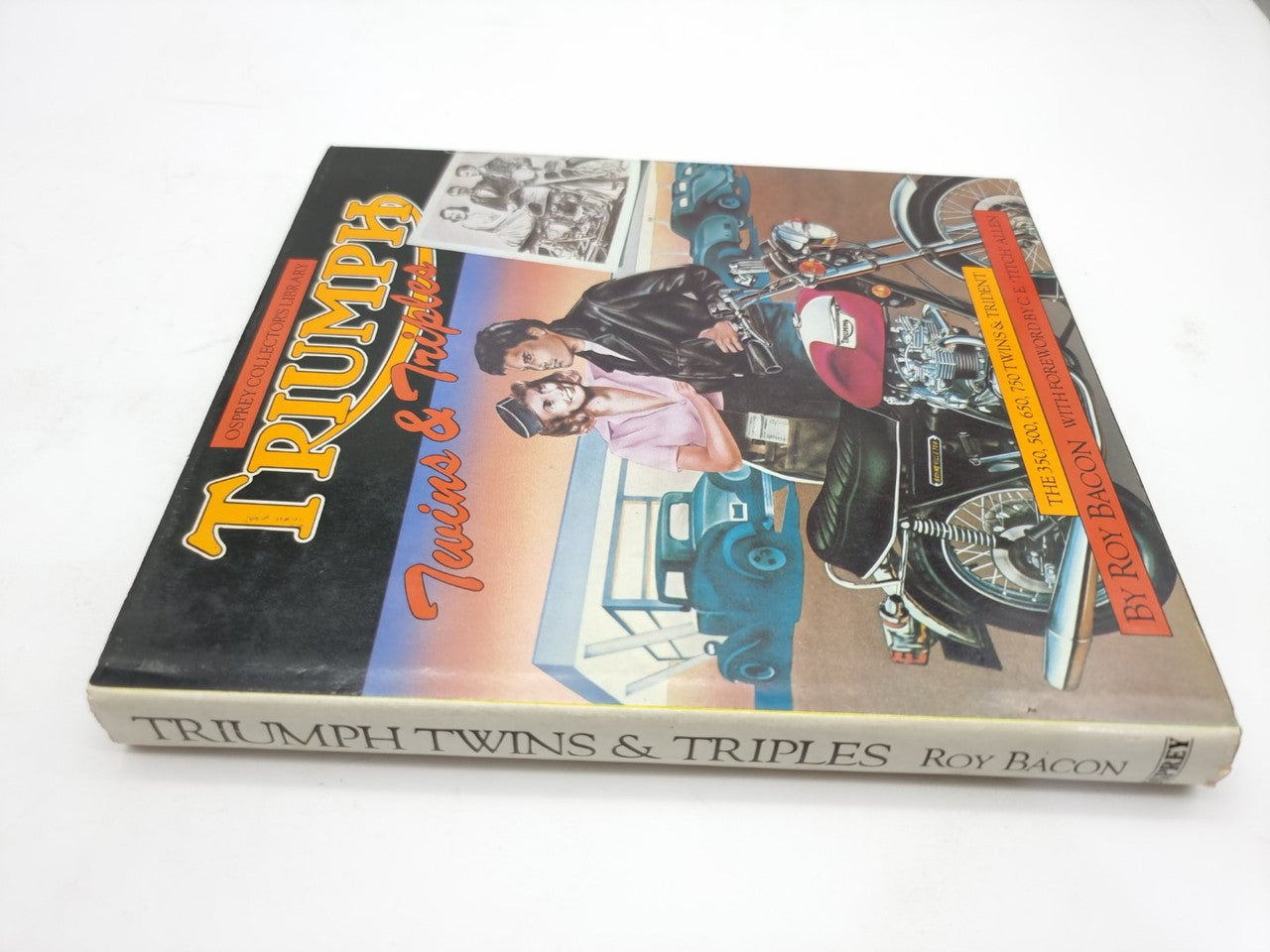 Motorcycle repair book with Triumph cover, featuring riders and engine diagrams on front