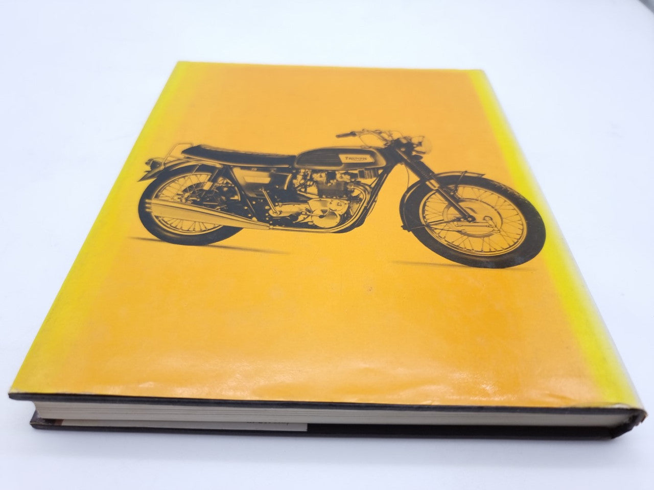 Yellow hardcover book with black motorcycle illustration and gray spine edge