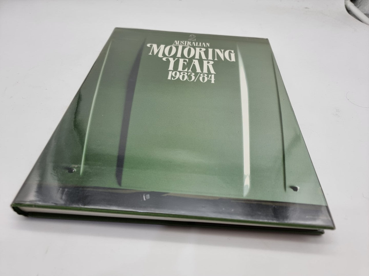 Green hardcover motoring yearbook with "Motoring Year 1983/84" on front cover