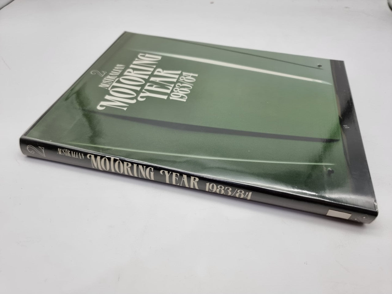 Green motoring yearbook with "Motoring Year 1983/84" title on spine and cover