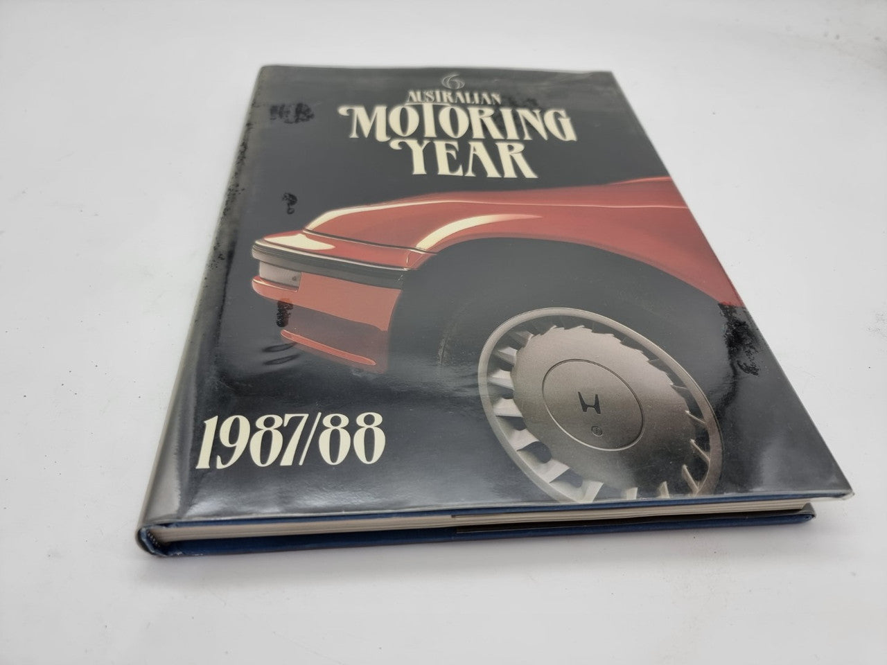 Motoring Year 1987/88 book with black, red car cover and wheel graphic