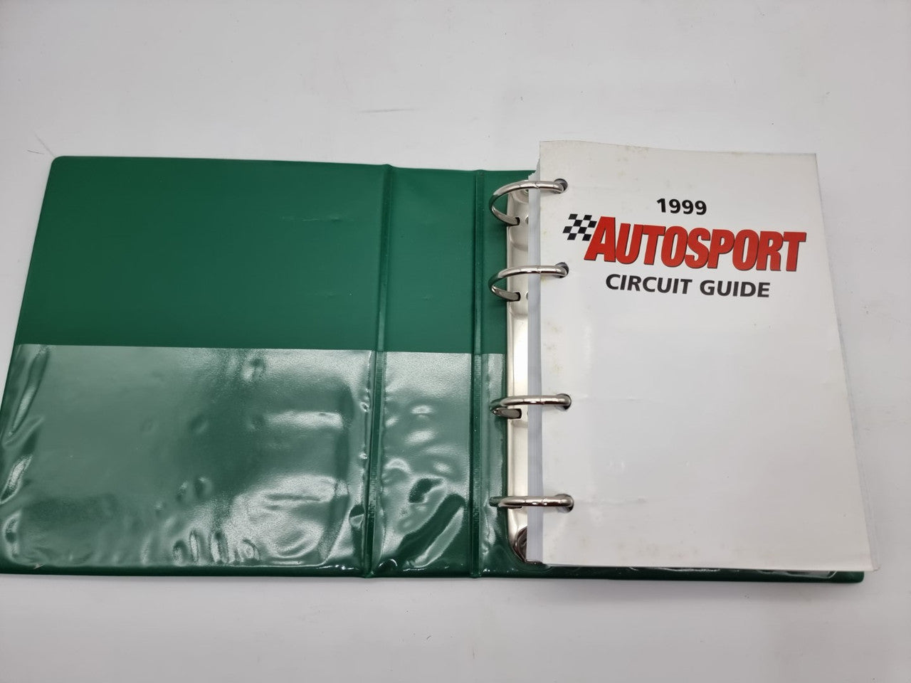 Open binder-style circuit guide with green cover and 1999 title page