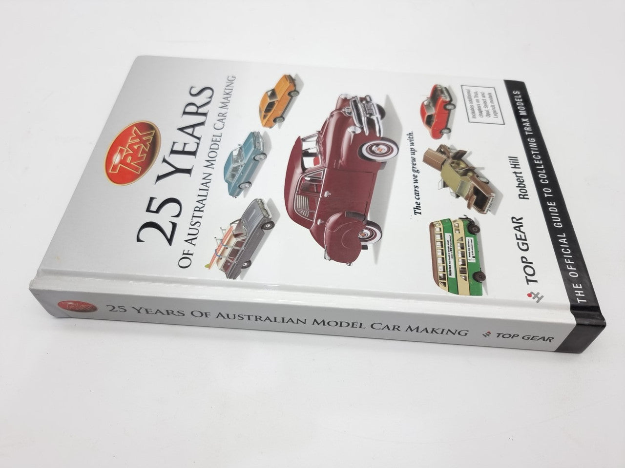 Model car making guide book with “25 Years” title and illustrated cars on the side