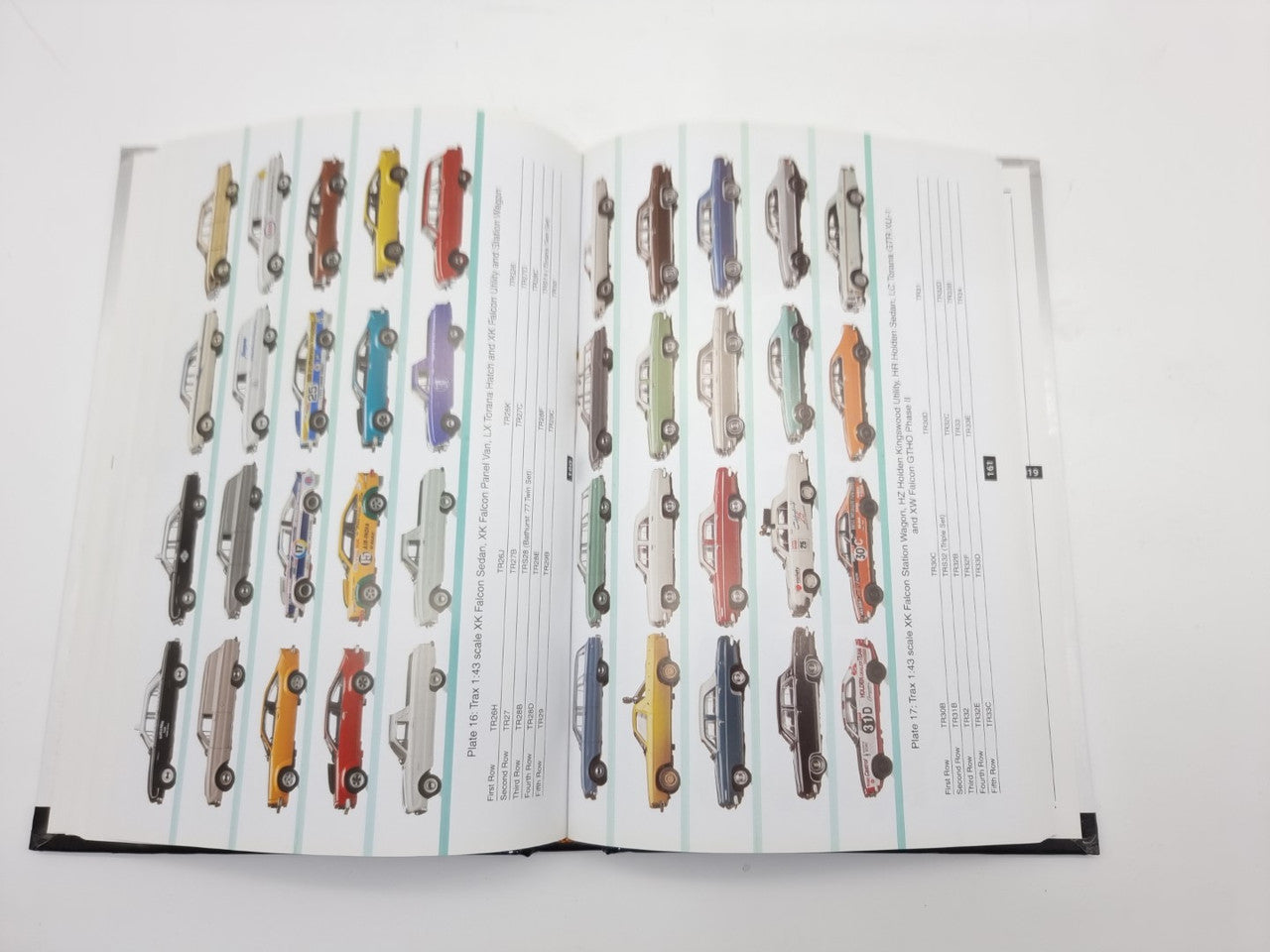 Model car guide book open to pages showing rows of miniature car models