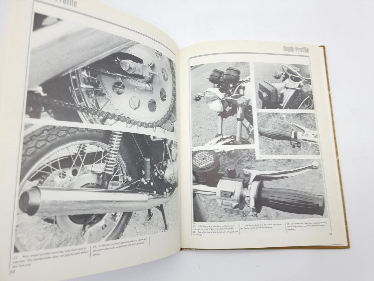 Open motorcycle manual with engine and parts photos across two pages
