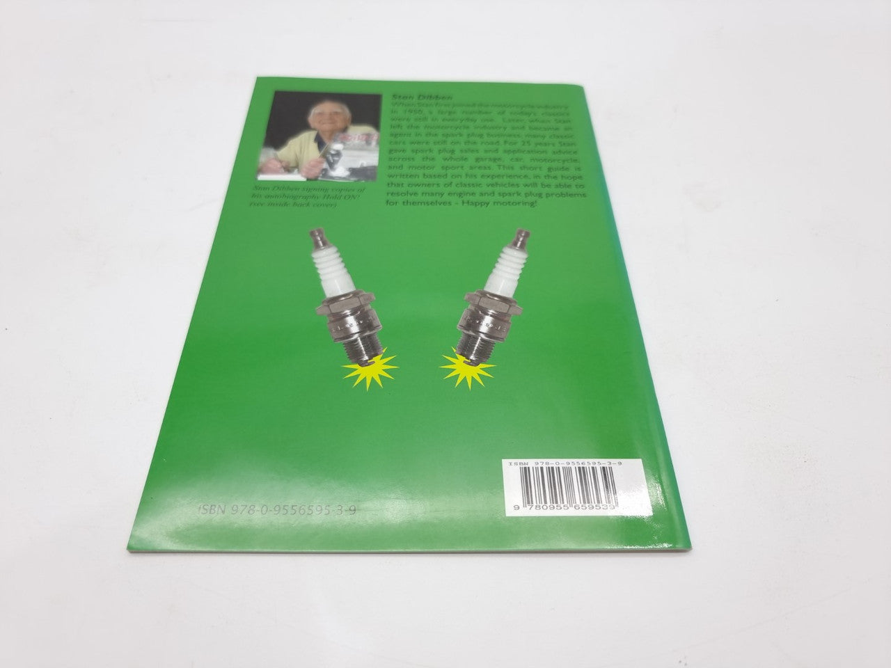 Paperback book back cover with two spark plugs, green background, barcode at bottom