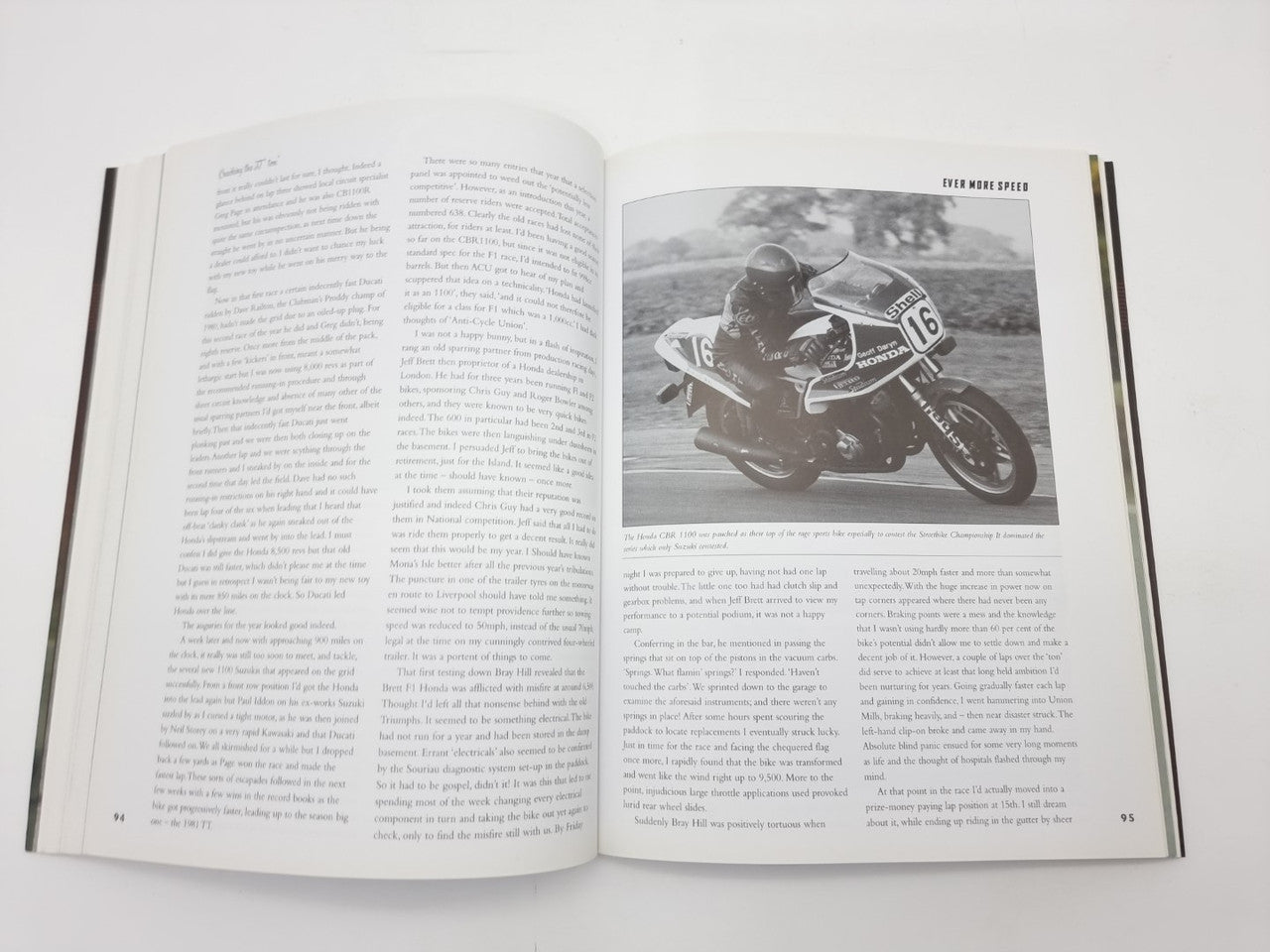Open paperback with racing chapter text and a full-page black-and-white motorcycle photo