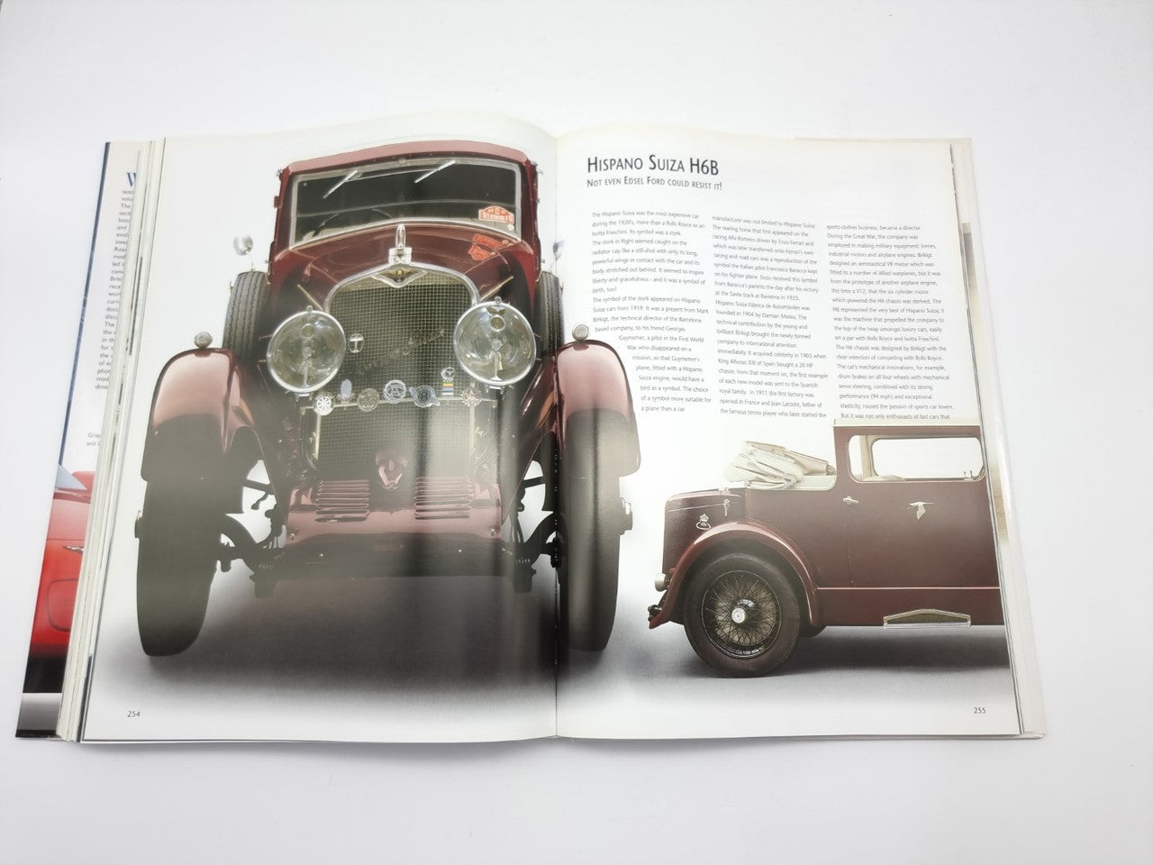 Open book with front and side photos of dark convertible cars and text columns