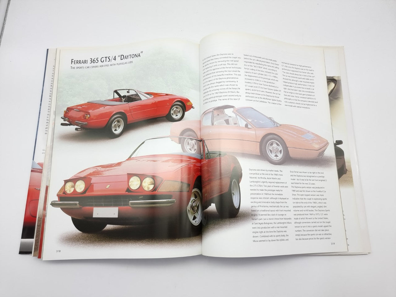 Open book with photos of a red convertible and a light-colored convertible on pages