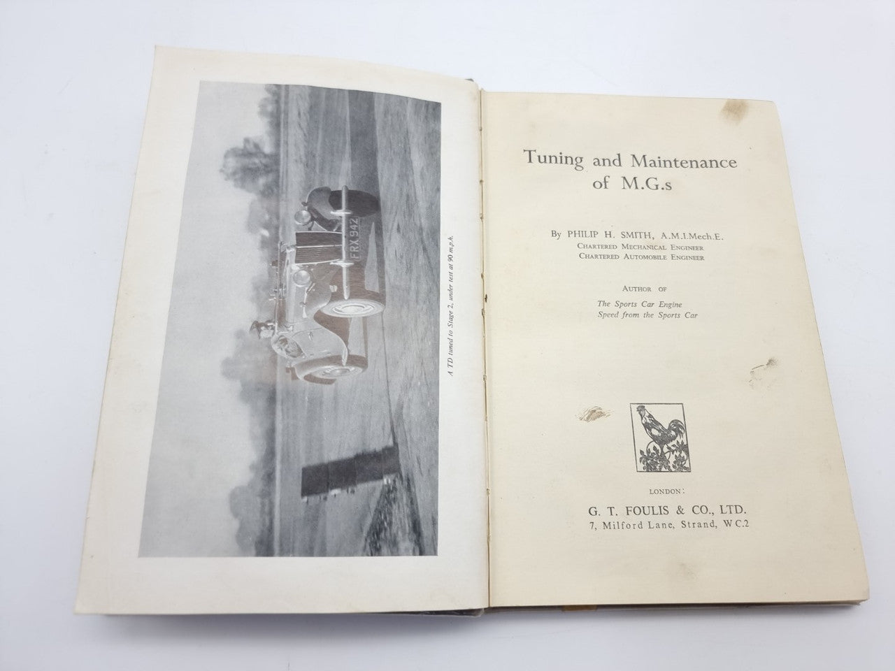 Open vintage car maintenance manual showing title page and engine illustration