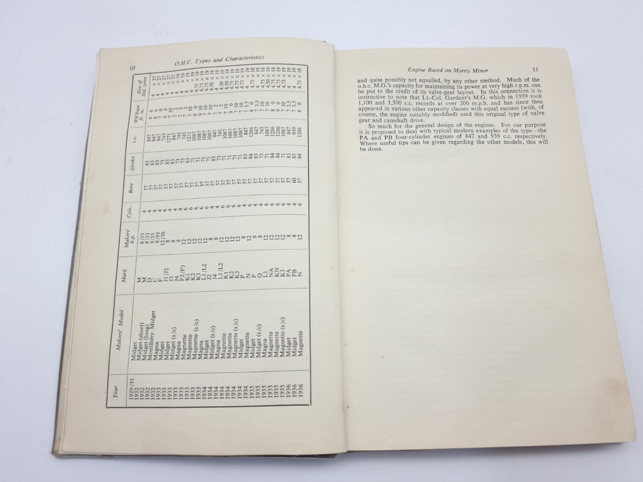 Open vintage car maintenance manual with charts, tables, and technical data