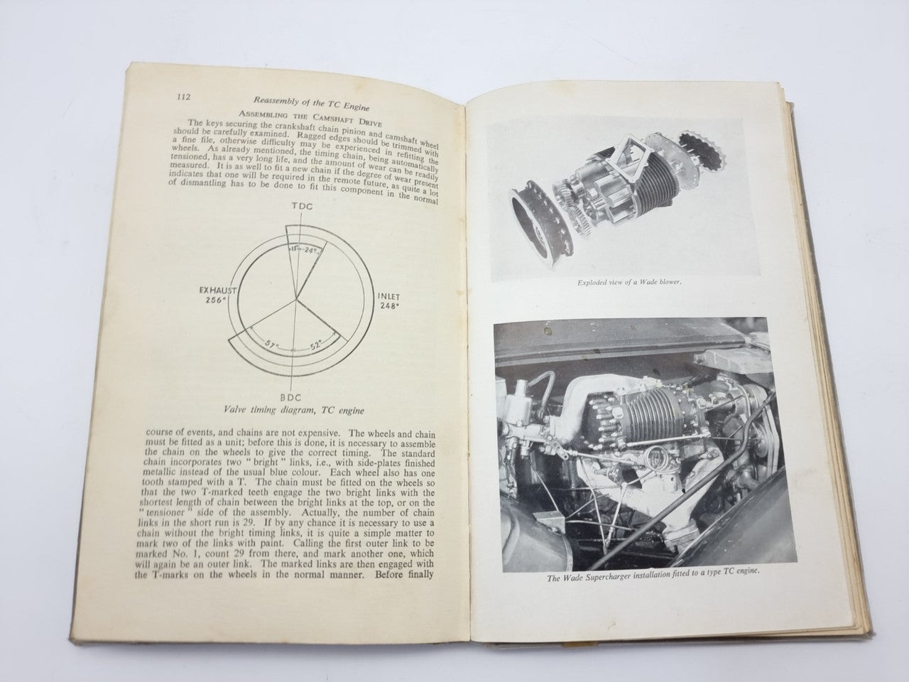 Open vintage car maintenance manual with circular gauge diagram and engine cross-section