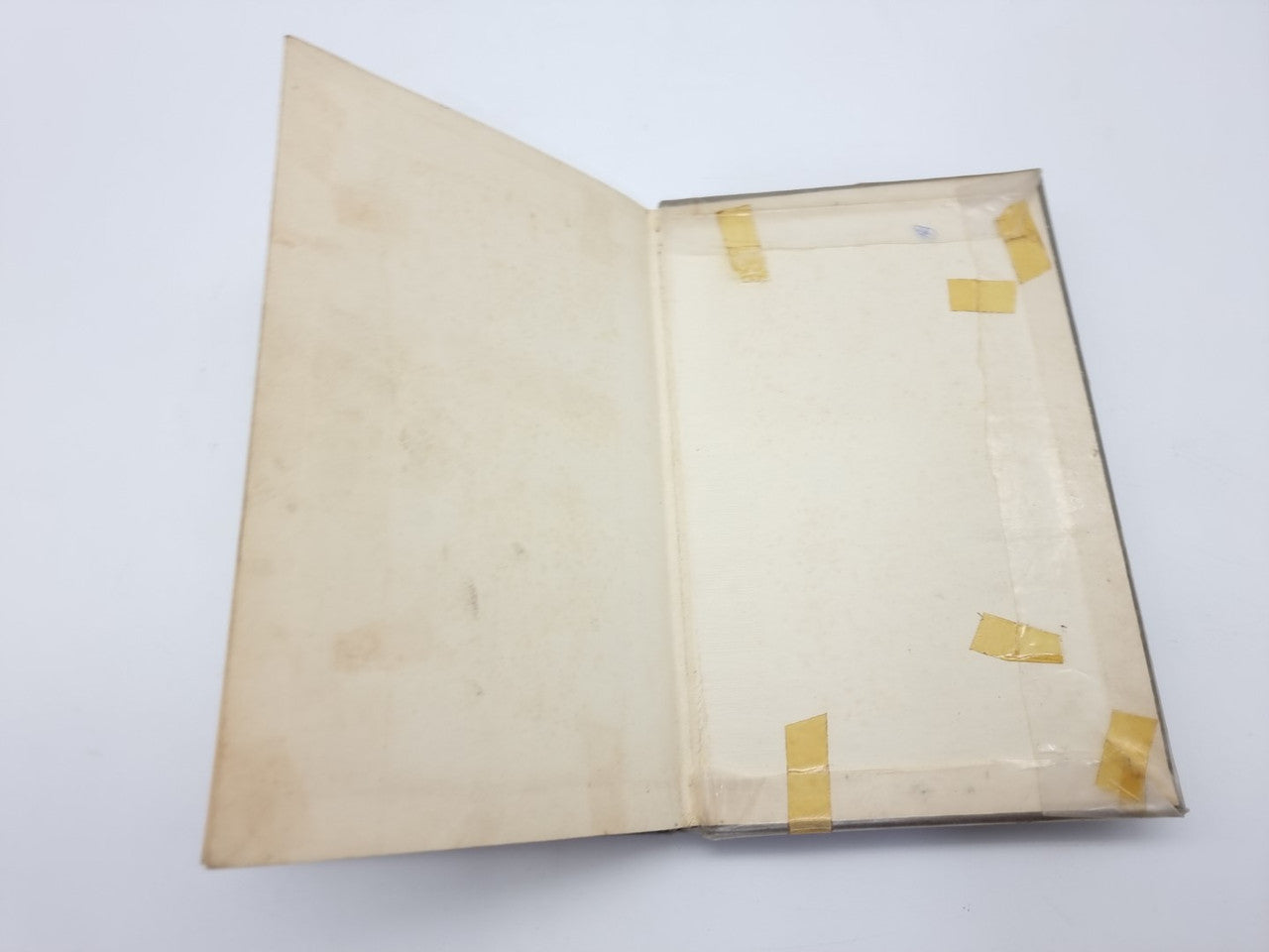 Closed vintage car maintenance manual with yellow tape marks on the covers
