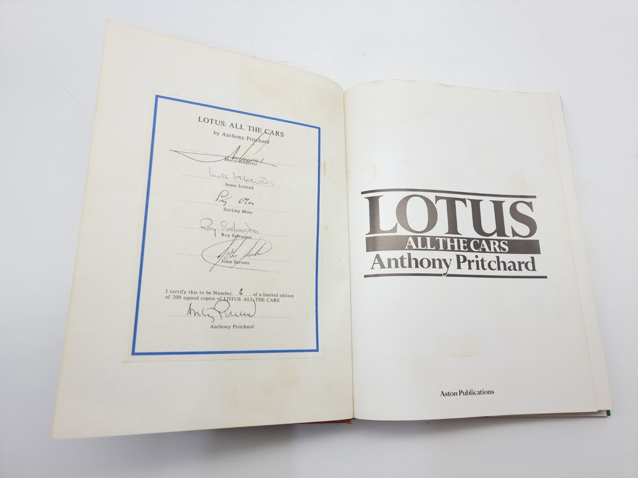 Open book with certificate page and title page for car racing history
