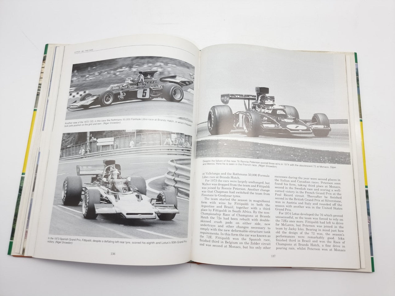 Opened motorsport photo book with two spread race photos and dense printed interview text