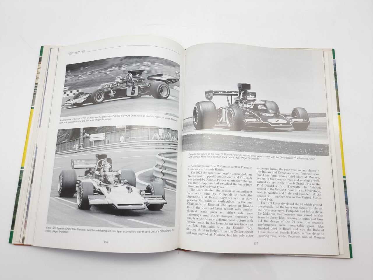Opened motorsport photo book with black-and-white single-seat race cars and article text