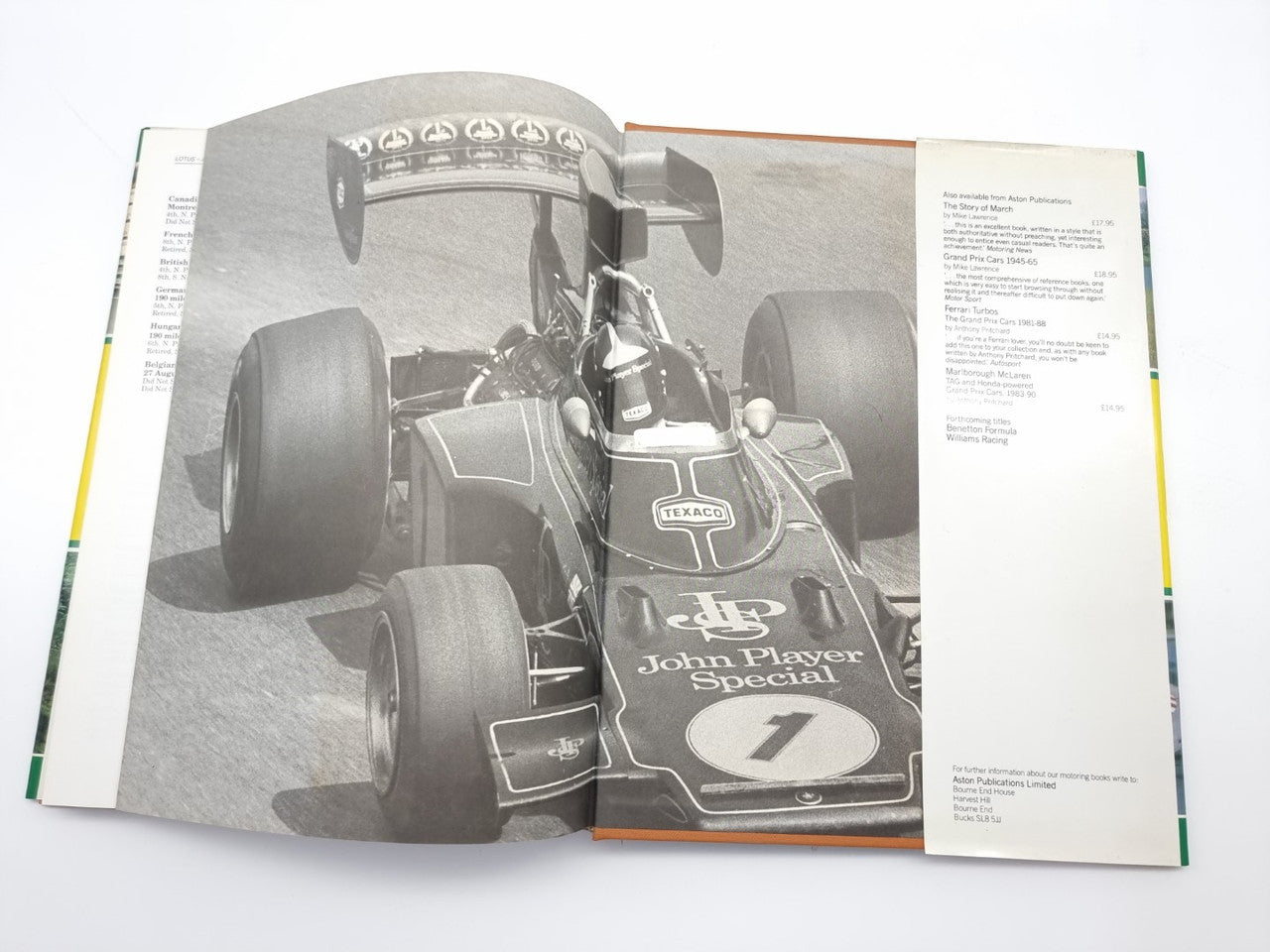Opened motorsport photo book with close-up of vintage race car cockpit and number 1