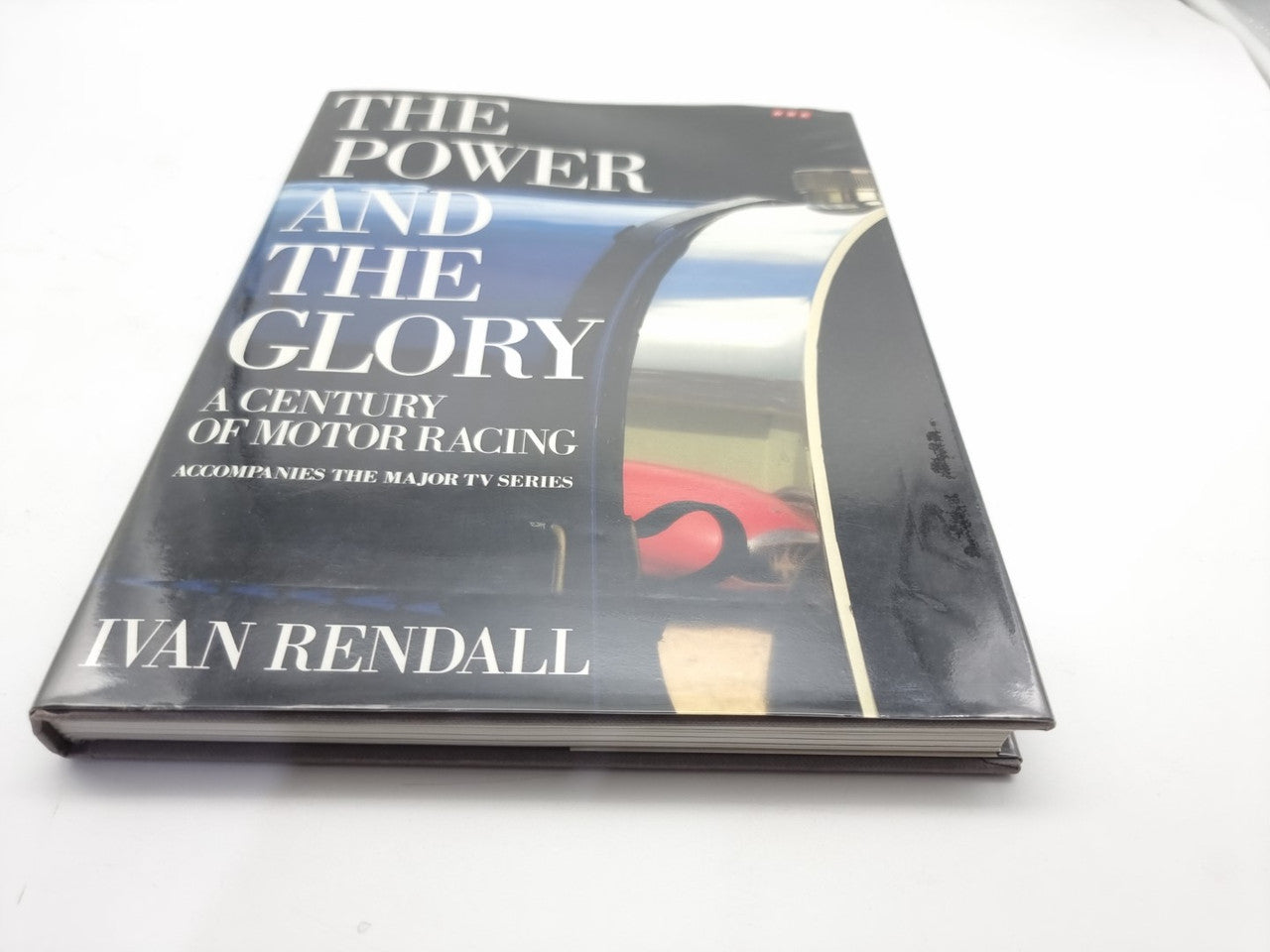 Motor racing history book with dark cover, title text, and author name