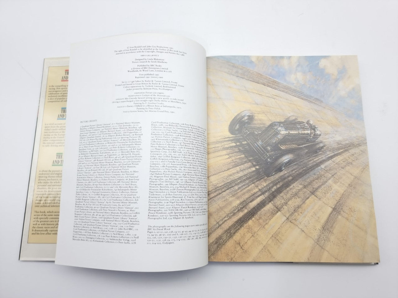 Open motor racing history book with technical race car image and printed pages