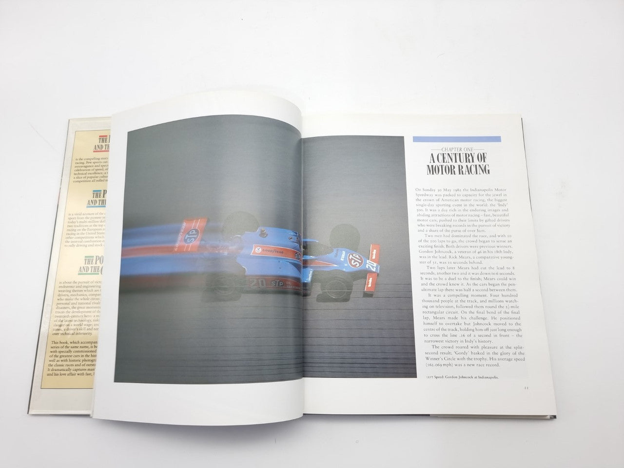 Motor racing book open spread showing racing scene photos and a section title page