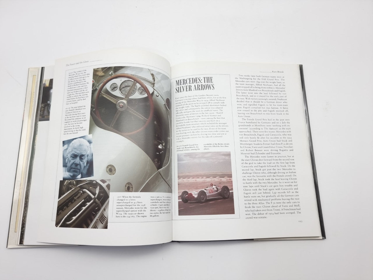 Motor racing book open spread with steering wheel close-up and race car photos
