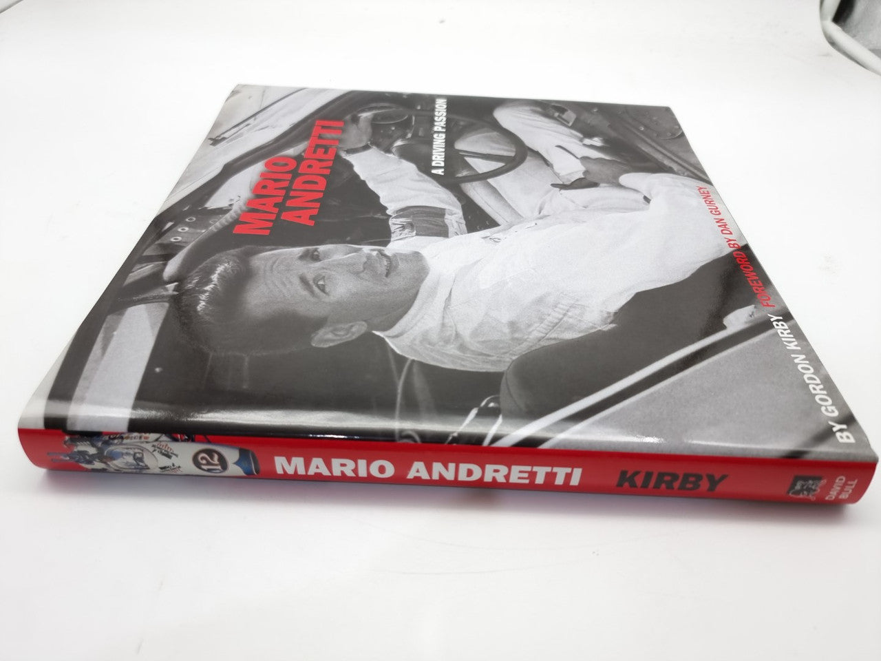 Racing book with angled cover view, red spine band and Mario Andretti title