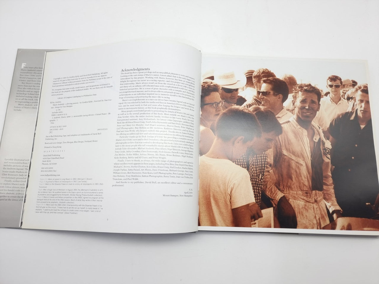Racing book open pages with dense text on left and group photo on right