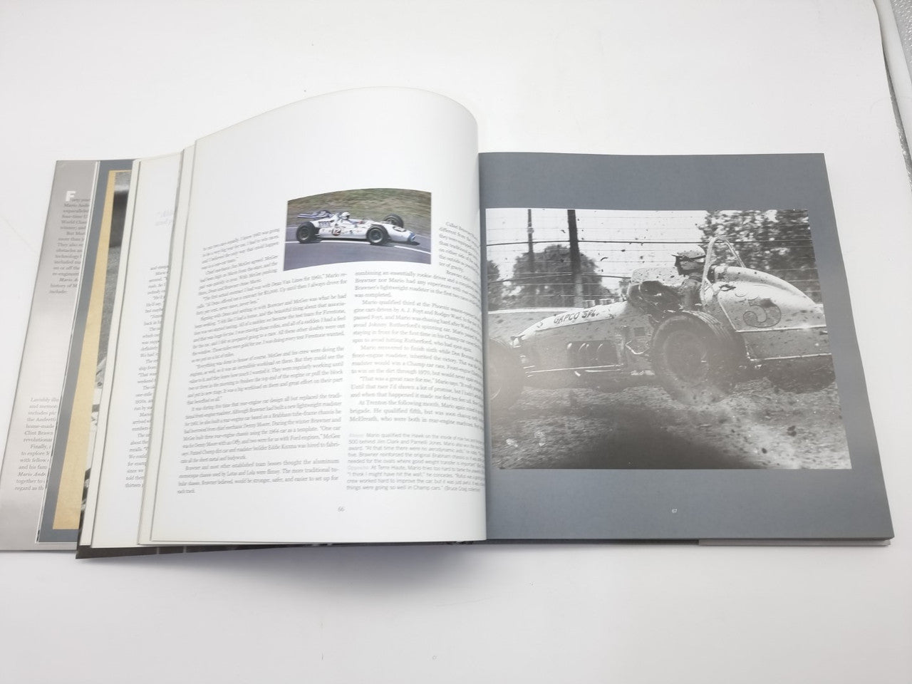 Open motorsport history book with text pages and small photo of a race car.