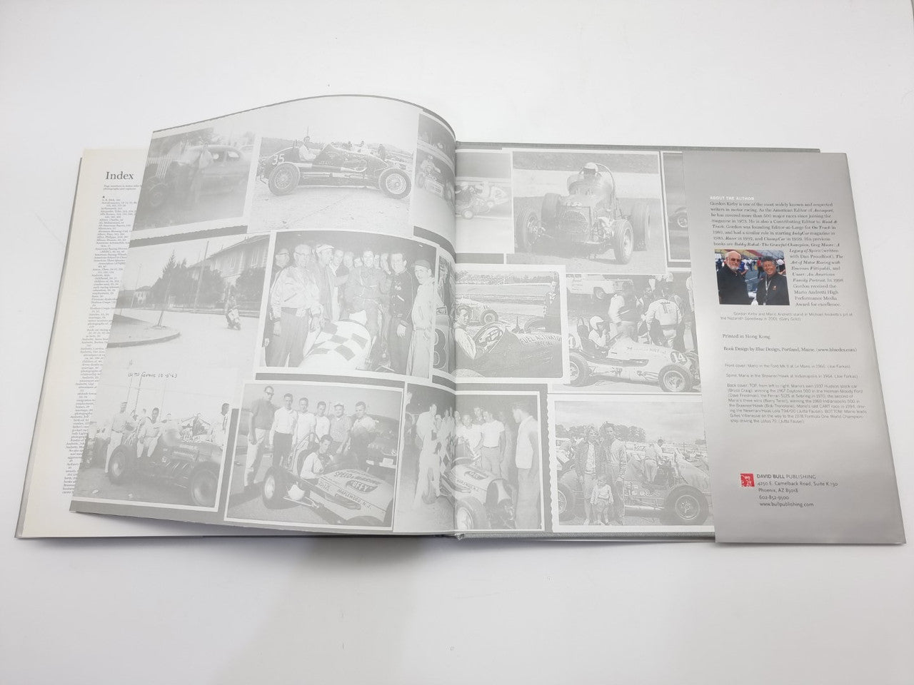 Open motorsport book spread with index and collage of small race-related photos.