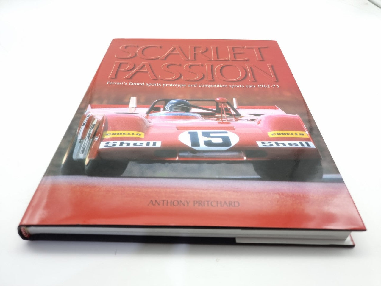 Hardcover automotive racing book with red cover and front-facing vintage race car