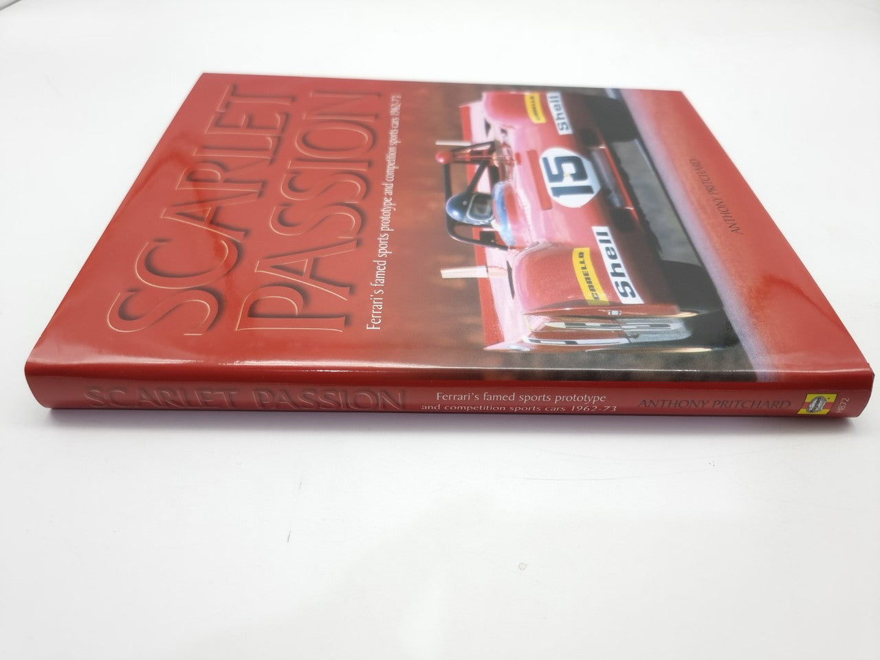 Red hardcover book with embossed title and racing car photo on cover