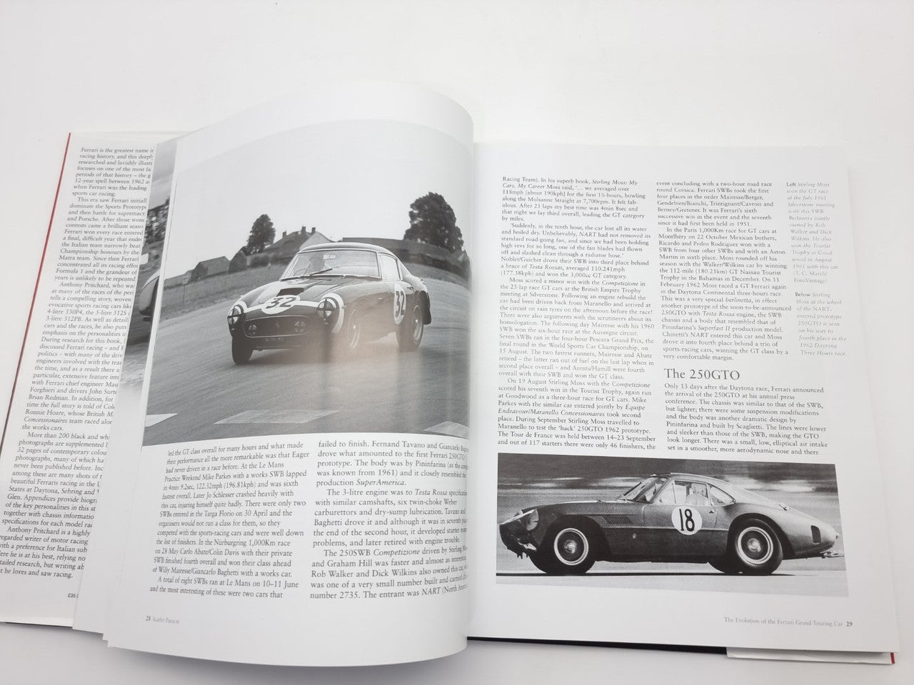 Open automotive history book with black-and-white race car photos and printed text