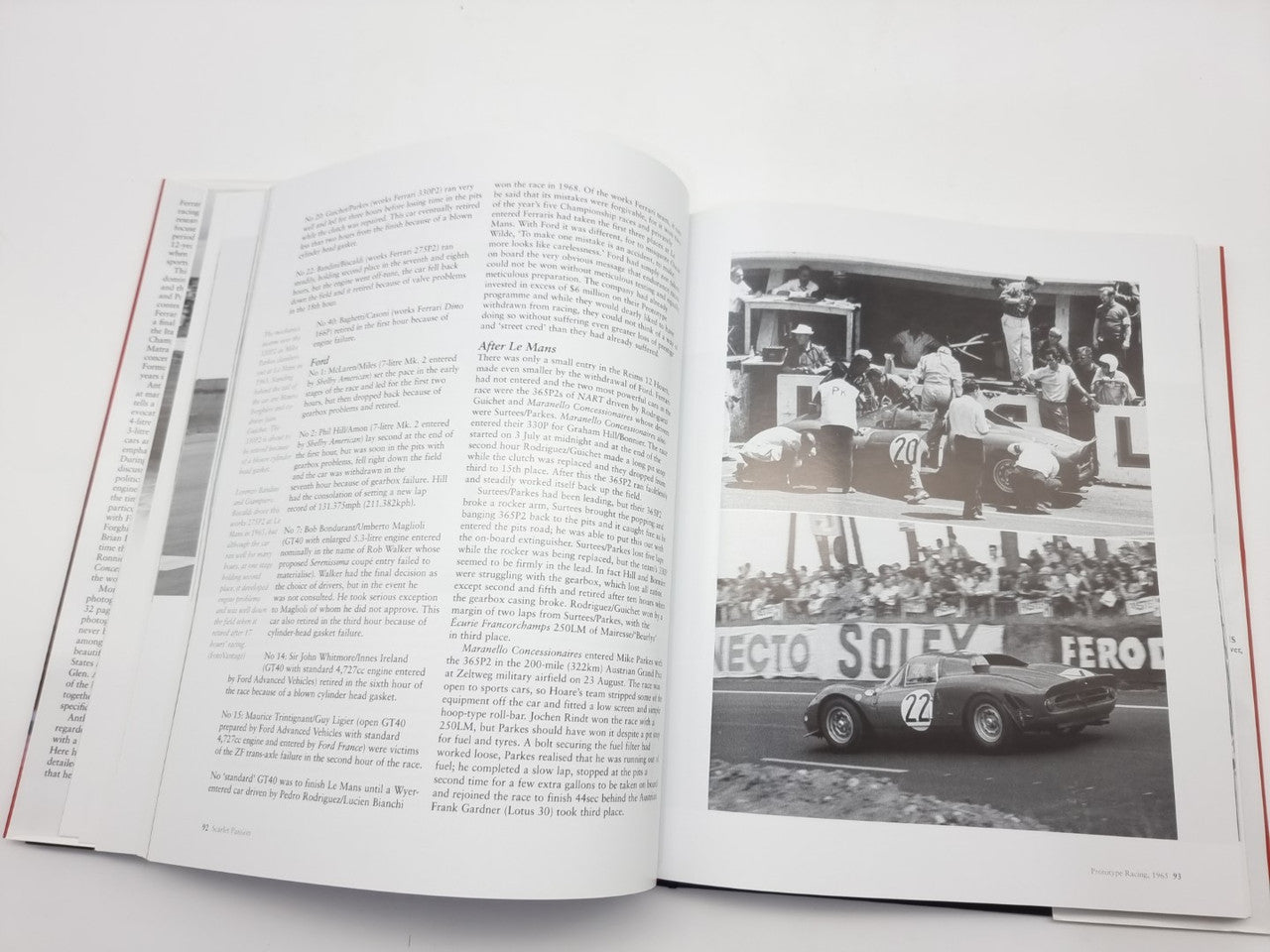 Open book spread with dense text and a black-and-white racing photo